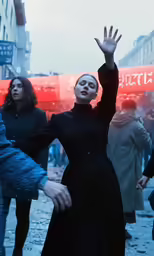 woman in black dress with arms outstretched above head