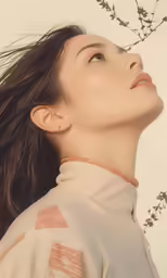 a woman in a sweater looks up to the sky