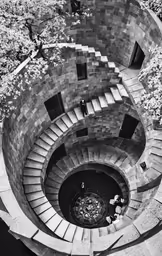 there is a spiral staircase with a man climbing the stairs