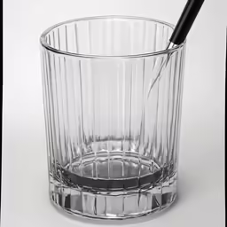 an empty glass has a pen sticking out of the top