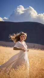 the woman is in the long dress walking through a field