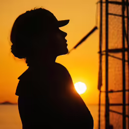 a person standing in front of the sun on the water
