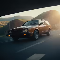 a car driving under an overpass in the mountains