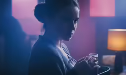 a person in a room with lights, a lamp and a cup
