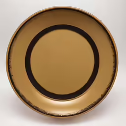 a golden plate that has some black circles on it