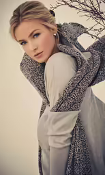 a beautiful blonde with blue eyes is posing
