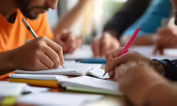 people who are writing on some paper at a table