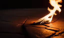 close - up of the end of a campfire burning on a wooden table