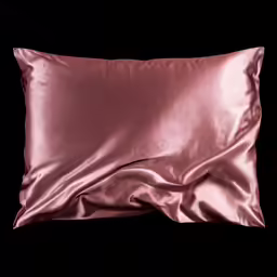 a pink pillow is laying on a black background