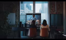 a couple of people sitting around a bar watching tv