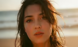a young woman on a beach is looking at the camera