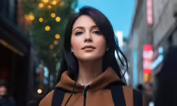 woman in hooded hoodie in downtown looking at camera
