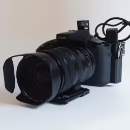 the lens with hood removed is resting near the camera