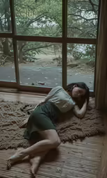a young woman laying on a bamboo mat near a window