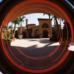 the house and courtyard are seen through a circular object