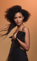 a beautiful young woman with curly hair wearing a black dress