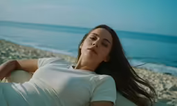 a young girl is laying on a white surfboard and smiling