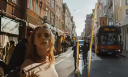 there is a woman walking down the street with other people