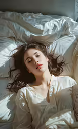 the woman is laying on a bed and stretching her arms