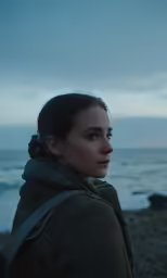 woman staring at the water on a gloomy day