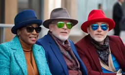 three men and woman with hats on sitting together