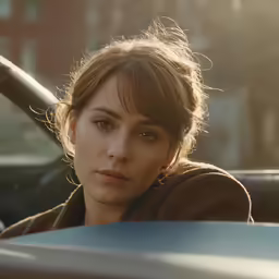 a woman sitting in a car looking at the camera