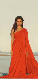 a woman in an orange dress poses by the water