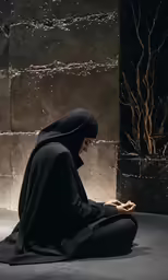 a woman sitting on the ground using her cell phone