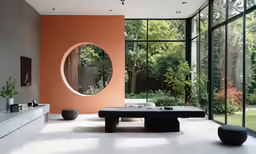 the modern living room features large windows and a circular mirror