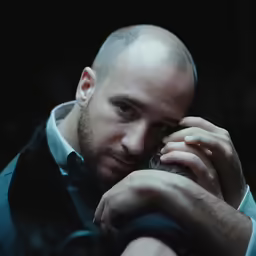 a man with a bald head is talking on a phone