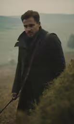 a man is in a field carrying an iron ladle