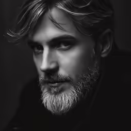 a man with a long hair and beard in black and white
