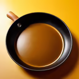 a brown frying pan on a yellow table