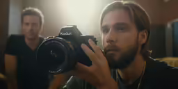 a man holding up a camera in front of his face