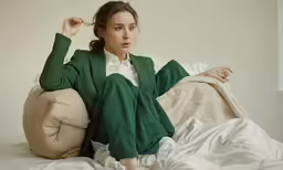 a young girl is posing for a photograph on the bed