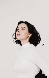 a woman posing in white clothes and black skirt