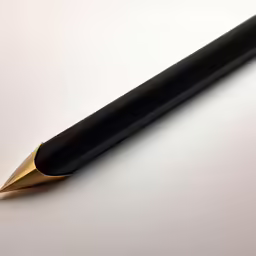 a pen is laying on top of a white surface