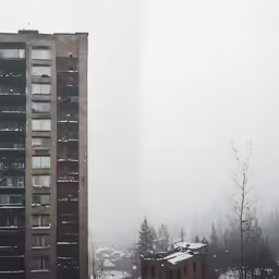 the view of a high rise building in the fog
