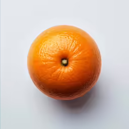 an orange with a small spot in the middle of its top