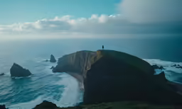 an island with two large cliffs and a person on it