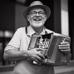 a black and white image of a man in an outfit holding a small computer