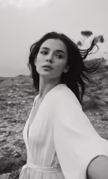 a woman is standing in a white dress outside