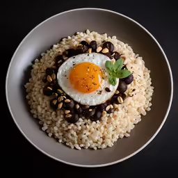 an egg is shown sitting on a dish with rice