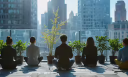a group of young people sitting on the ledge near plants