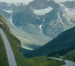 there are mountains behind the road that goes into the distance