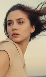 a beautiful woman with long hair in a white dress looking away