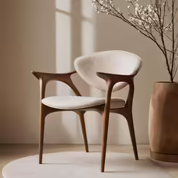 a wooden chair in front of a vase of flowers
