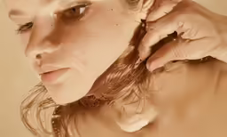 the girl has a ponytail that is holding her hair in her hand