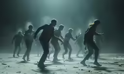 a group of people are dancing in a dark area