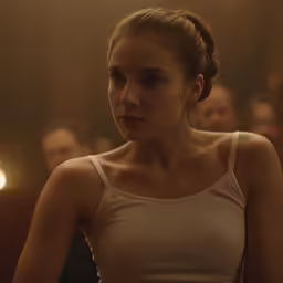 a woman in a tank top standing by some people